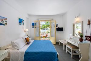 a bedroom with a blue bed and a desk at Margarita Studios in Parikia