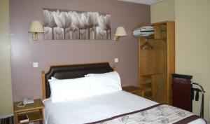 a bedroom with a bed and a lamp at Cardiff Sandringham Hotel in Cardiff