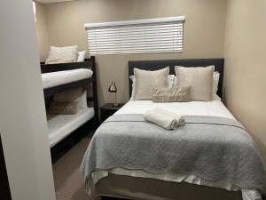 a bedroom with a bed and two bunk beds at Ballito Manor - Manor Gardens 204 - complex generator in Ballito +20 photos