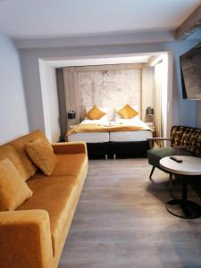 a living room with a couch and a bed at Liebig Hotel in Ehringshausen