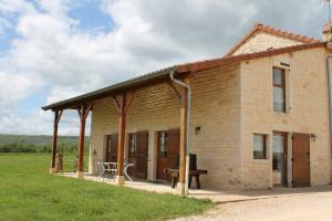 ein Backsteingebäude mit einem Picknicktisch davor in der Unterkunft Domaine Joseph LAFARGE Wine Resort WineMaker House La maison du Vigneron in Lugny