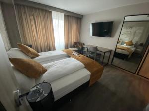 a bedroom with a large bed and a living room at Liebig Hotel in Ehringshausen