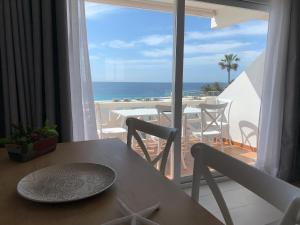 een tafel en stoelen met uitzicht op de oceaan bij Apartamento en Playa Santo Tomas in Es Migjorn Gran