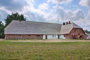 an old brick barn with a gray roof at Vastseliina Piiskopilinnus 