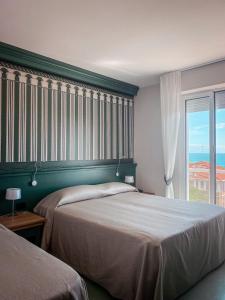 a bedroom with two beds and a large window at MH HOTEL VARAZZE in Varazze