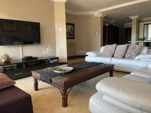 a living room with two couches and a coffee table at Ballito Manor - Manor Gardens 204 - complex generator in Ballito