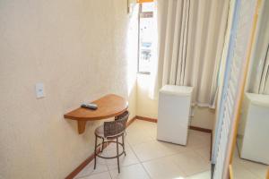 a small table and a chair in a room at Pousada Ondas do Forte in Cabo Frio