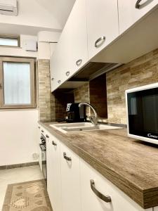uma cozinha com um lavatório e um micro-ondas em Dimora Sportelli em Polignano a Mare
