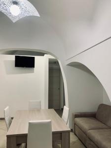ein Esszimmer mit einem Tisch und einem Sofa in der Unterkunft Dimora Sportelli in Polignano a Mare