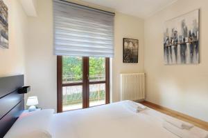 sypialnia z białym łóżkiem i oknem w obiekcie Casa Nives - By Impero House w mieście Stresa