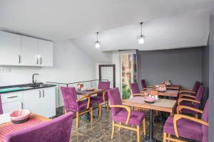 イスタンブールにあるLa Petite Maison Hotelの紫色の椅子とテーブルが備わるダイニングルーム