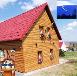 uma cabana de madeira com um telhado vermelho em ,,POD SKAŁKAMI '' ŚWIERADÓW ZDRÓJ-okolica ,POKOJE Z ŁAZIENKAMI I ANEKSAMI KUCHENNYMI em Giebułtów