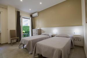 2 camas en una habitación con ventana en Six Rooms en Nápoles
