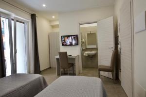 Pokój hotelowy z sypialnią z biurkiem i lustrem w obiekcie Six Rooms w mieście Neapol