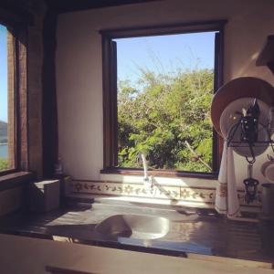 cocina con fregadero y ventana en Chalé de Pedras no Pontal do Atalaia, en Arraial do Cabo