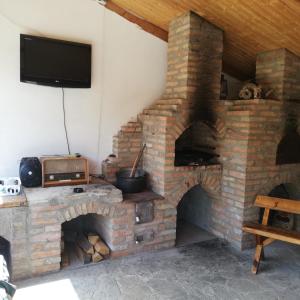 a brick oven with a television on top of it at Casa din Barcut in Bărcuţ