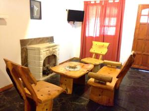 Un comedor con mesa y sillas y chimenea. en Cabañas Luján, en Potrero de los Funes