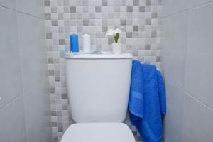 a white toilet in a bathroom with blue towels at Barcelona City Rooms in Barcelona