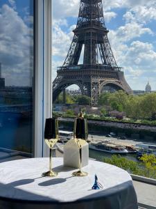 a table with two wine glasses in front of the eiffel tower at Eiffel Tower romantic view in Paris