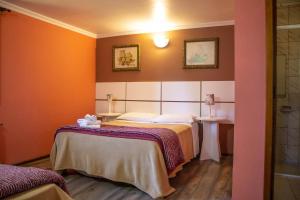 1 dormitorio con 1 cama con paredes de color naranja en Estalagem Schmitt Haus, en Canela