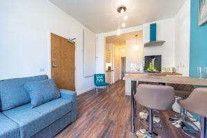 a living room with a blue couch and a table at Mandela House Apartments in Kirkcaldy