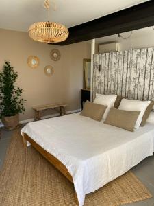 Auriol的住宿－La Maison Perchée，卧室配有一张大白色的床和大床头板
