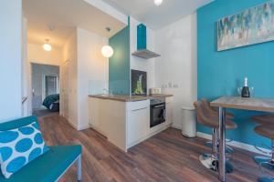 a kitchen with blue and white walls and a table at Mandela House Apartments in Kirkcaldy