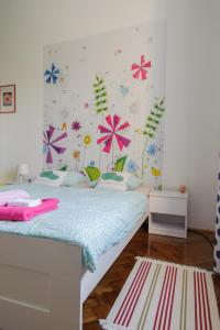 een slaapkamer met een bed met bloemen aan de muur bij Cozy river view apartment in Karlovac