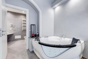 Baño blanco con bañera y lavamanos en Maison Degli Artisti Suites, en Roma