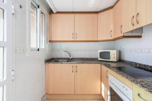 a kitchen with a sink and a microwave at A beautiful 2 bedroom townhouse - Las Cerezas in Ciudad Quesada