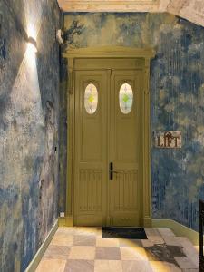 a yellow door in a room with blue walls at Lift Hotel Boutique in Odesa