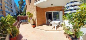 a patio with a table and chairs next to a building at Kesito Family Apartments in Lloret de Mar