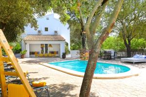 a swimming pool in front of a house at Villa Romaní in Sa Pobla