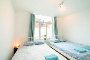 2 camas en una habitación con ventana en The Fashion Street Residence en Amberes
