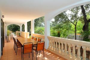 a patio with a wooden table and chairs on a balcony at Villa Romaní in Sa Pobla