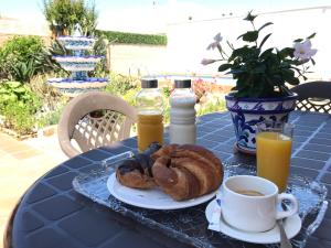 - une table avec un plateau de pâtisseries et une tasse de café dans l'établissement Casa Pedro, à Roquetas de Mar