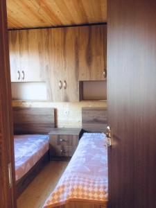 two beds in a room with wooden cabinets at Cottage in Tʼelavi