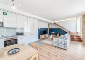 a large kitchen and living room with white cabinets at Mouzinho da Silveira Unique Apartments, by Oporto Collection in Porto