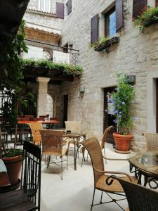 a patio with tables and chairs and a building at B&B Rooms Old Town Rab in Rab