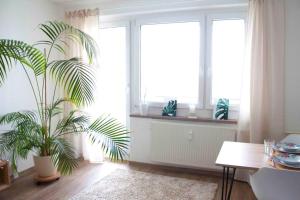 a living room with a table and a plant at Modernes 2-Zimmer-Apartment mit Balkon und Netflix in Jena