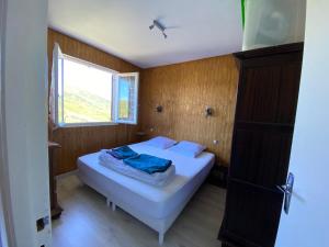 Habitación pequeña con 2 camas y ventana en Chalet Ascou-Pailhères en Ascou