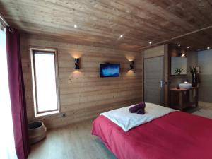 a bedroom with a large bed in a wooden wall at NOUVEAU ! Chalet Grand Croix - Haut Standing - 8, 10 pers in Lanslebourg-Mont-Cenis