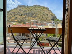 balkon z 2 krzesłami i góra w tle w obiekcie Nafplia Hotel w Nauplionie
