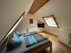 a bedroom with a bed in a attic with a window at Ferienhaus Neumeyer in Schönau