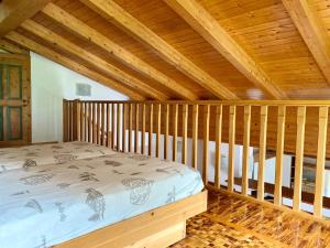 Cama en habitación con techo de madera en Casa Pallanch, en Fai della Paganella