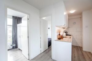 a kitchen with white walls and a counter top at Papillon flat in Zandvoort