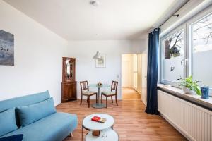 a living room with a blue couch and a table at Appleslounge in Dahlem
