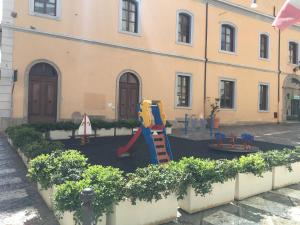 un parque infantil frente a un edificio en Intra Rooms, en Olbia