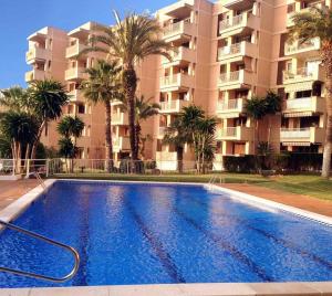 una piscina frente a un gran edificio de apartamentos en Karin Palma Fiesta-Vallpineda-Sitges, en Sant Pere de Ribes