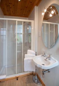 a bathroom with a shower and a sink and a mirror at Myrtle Bank Guest House in Fort William +36 photos
